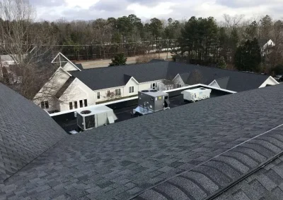 A large commercial building with multiple dark asphalt shingle roofs in Richmond, VA.