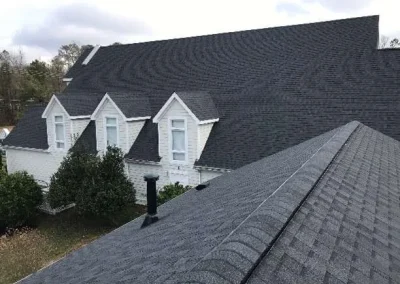 A spacious building with dark asphalt shingle roofing and dormer windows in Richmond, VA.